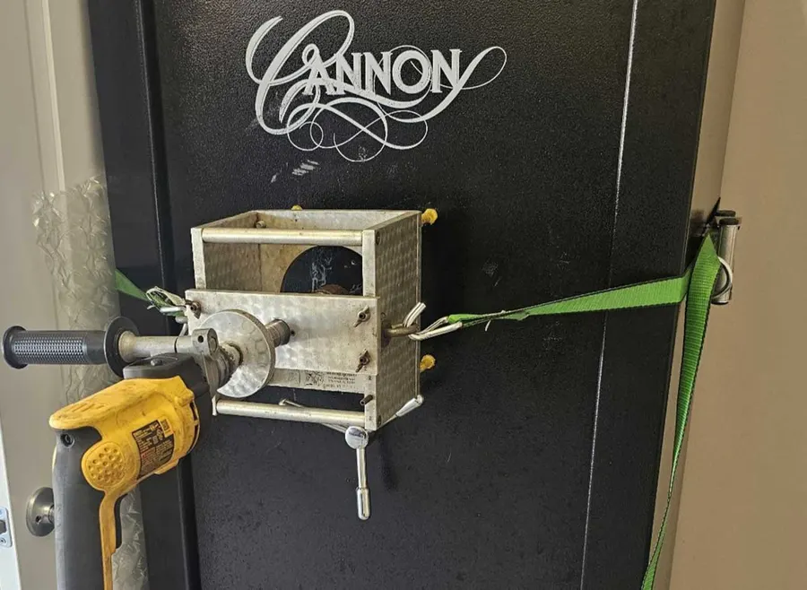 Drill rig mounted on a gun safe door during a safe opening
