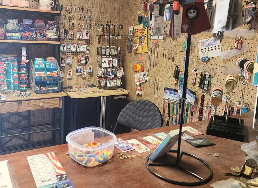 Shop counter with key rings, decorative keys, and accessories on pegboard displays